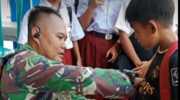 Anggota Satgas TMMD Ke 121 Kodim 1210/Landak Bantu Merapikan Seragam Anak-Anak Sekolah